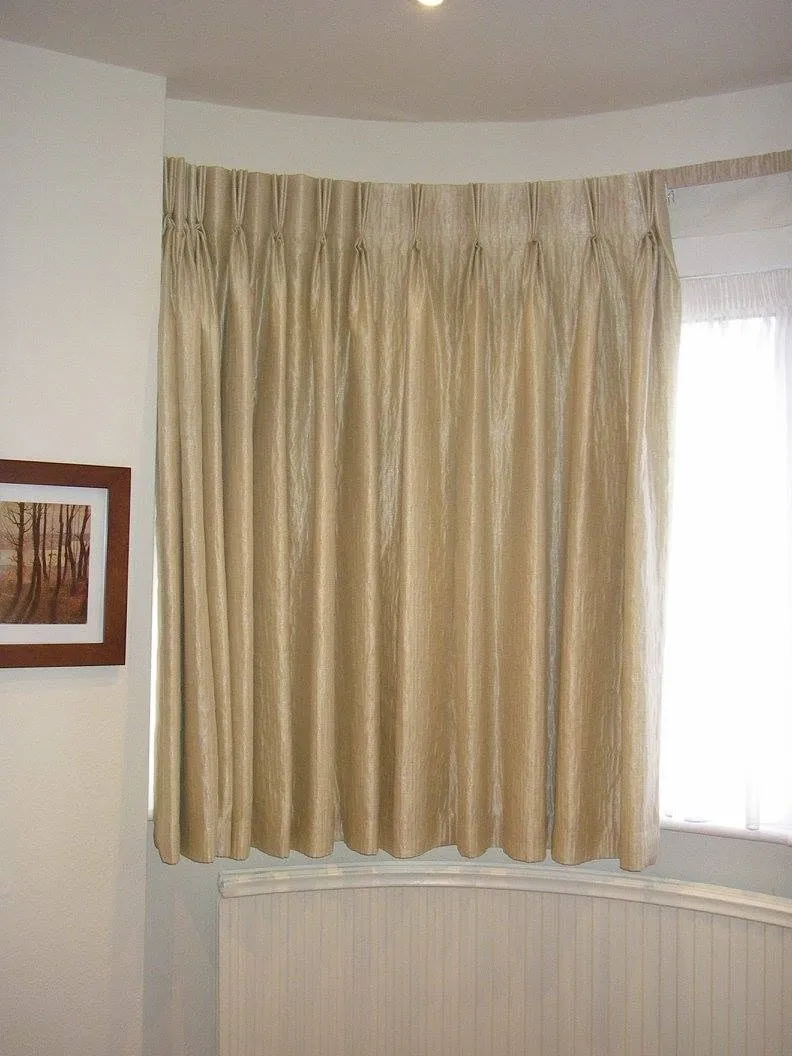 Made-to-measure champagne curtains fitted around an elegant bay window